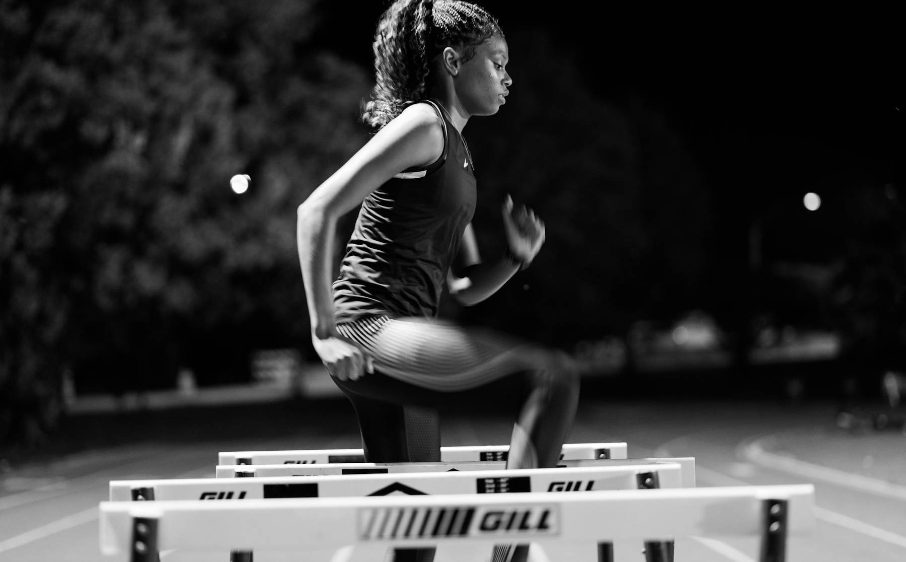 Atleta saltando una valla en la pista
