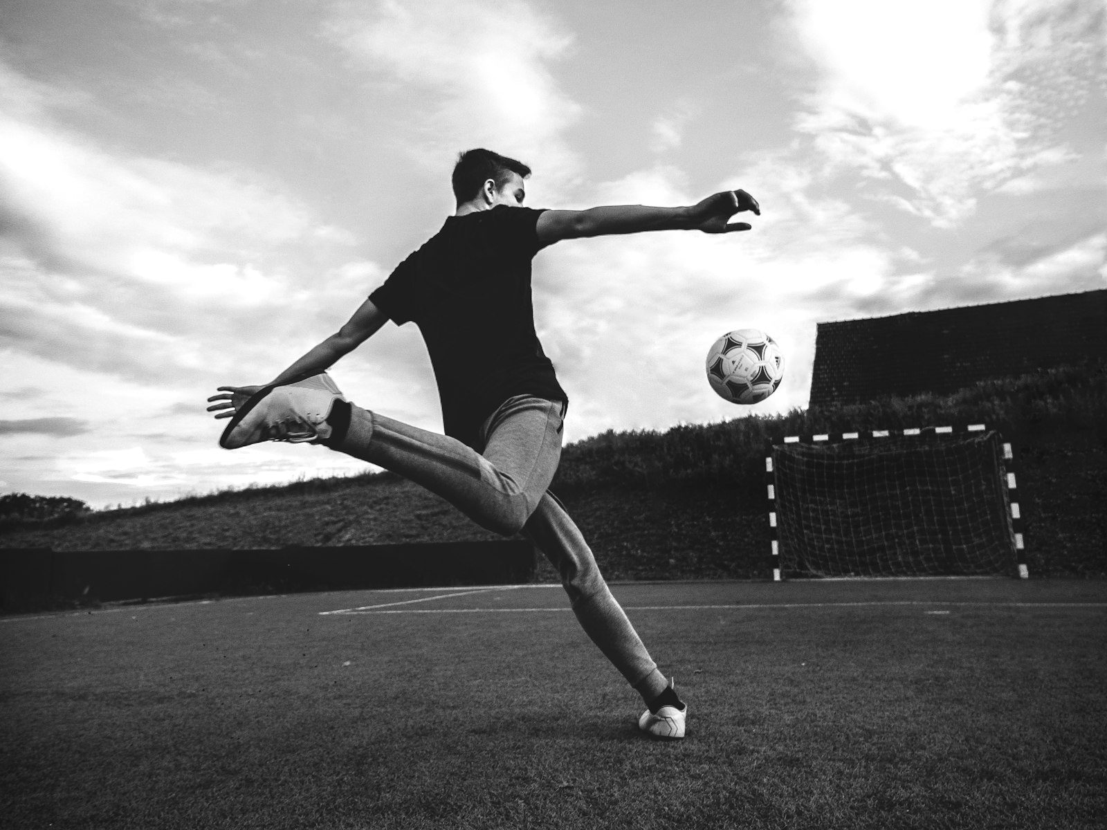 Futbolista rematando un balón hacia la portería